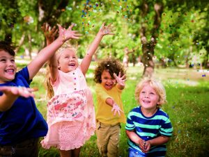 Happy Child Friends Having Fun With Confetti In A Park